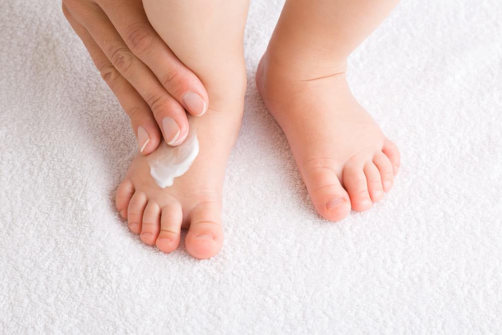 Baby lotion on a baby's foot