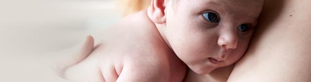 Parent skin to skin with newborn baby