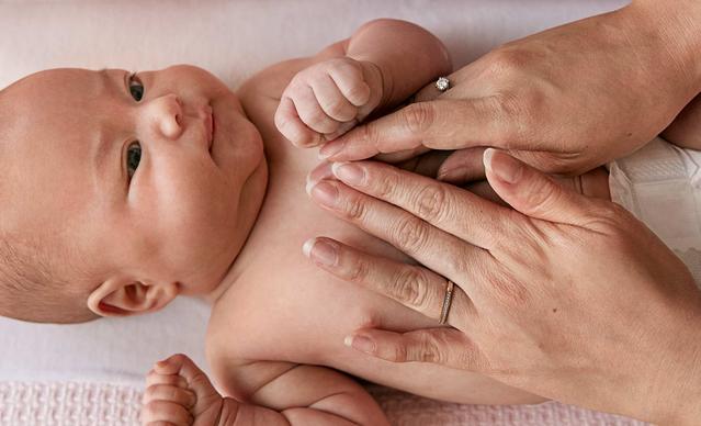 Parent Massaging a Newborn Baby's Chest